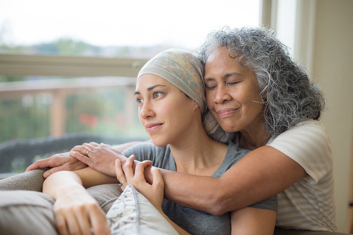 Daughter getting comfort from mother during treatment at Ascension Saint Agnes Hospital Cancer Institute.