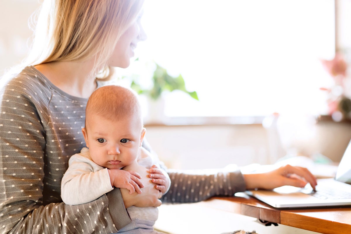 A mom holding her baby while scheduling an appointment