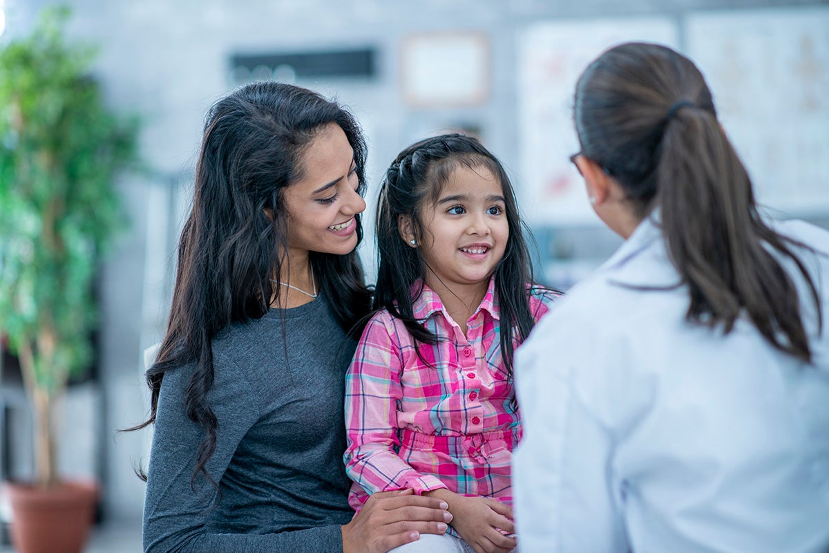 A doctor talking to a mom and her daughter
