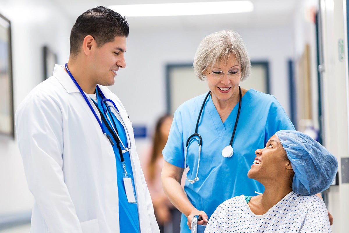 Ascension care team speaking with a patient seated in a wheelchair before a procedure.