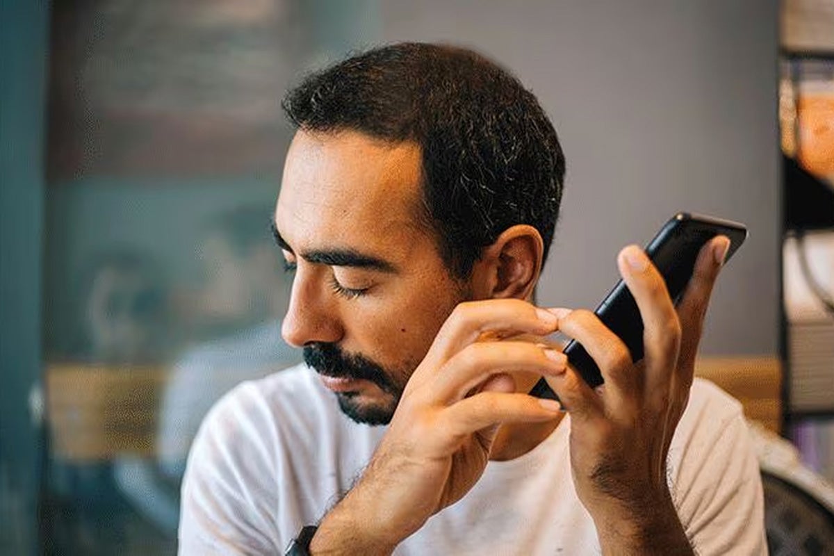 Man holding a smartphone near his face.
