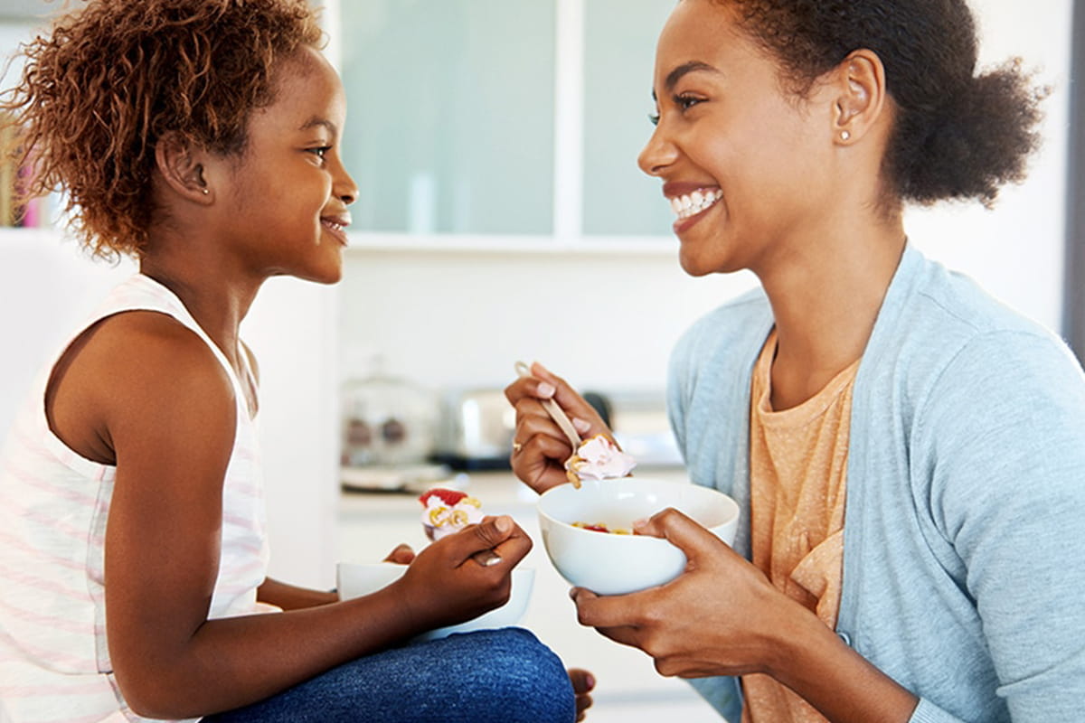 Mother and daughter eating yogurt.