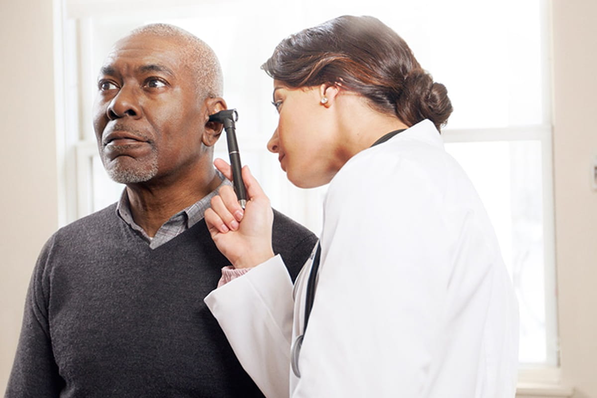 Doctor checking a man's hearing