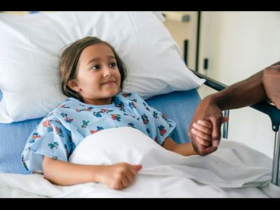 Little girl in hospital bed.