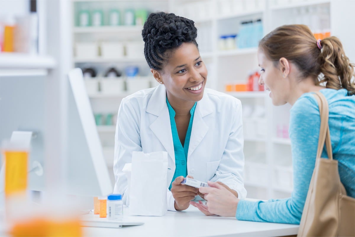 Pharmacist talking with a woman about medications.