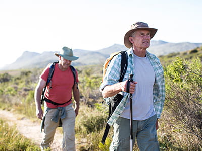 Skin cancer patient enjoys a hike through the mountains with his friend.