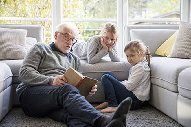 Man reading to his grandkids after getting a heart scan from an Ascension site of care. 