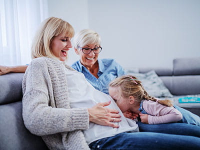 Mom and daughters laughing on couch