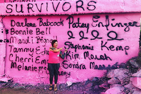 Stephanie Kemp standing in front of the Graffiti Bridge in Pensacola, Florida 