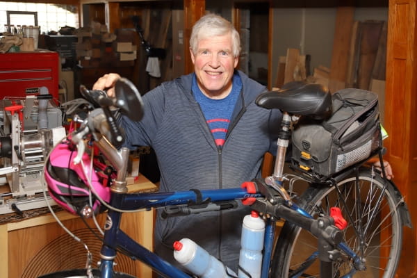 Gastric sleeve surgery patient Rich Piper holds up his bicycle in his woodworking workshop