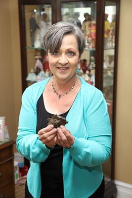 Chicago breast cancer survivor Karen Wilson holding shrapnel from a WW2-era bomb