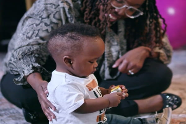 Laverne Goffney sitting next to her baby boy playing with a toy