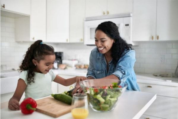 Mother and daughter cooking a healthy meal together.