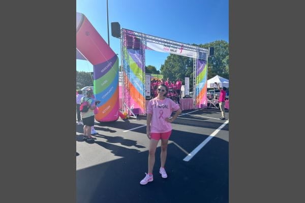 Morgan Payne poses at a fun run for breast cancer awareness wearing a pink t shirt that says "I Won"