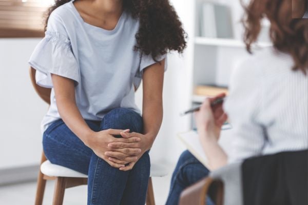 A woman sits in a chair and talks to her OB GYN at an Ascension Wisconsin facility.