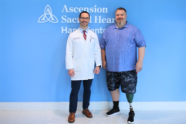 Ascension Sacred Heart orthopedic surgeon, Dr. Russel Holzgrefe, poses with patient John G.
