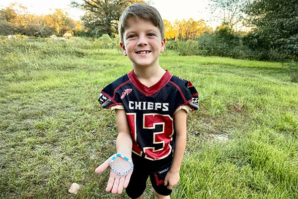 Russell shows bracelet he makes to inspire others