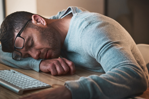 A man sleeping at his desk.