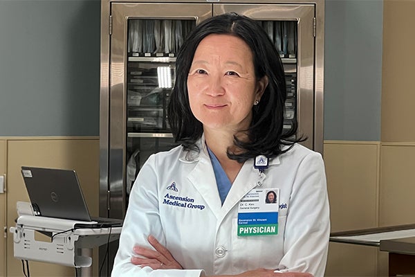 Dr. Christina J. Kim, breast surgical oncologist at Ascension St. Vincent Fishers, stands in a clinical setting, highlighting her commitment to personalized breast cancer care and annual mammogram screenings for women over 50.