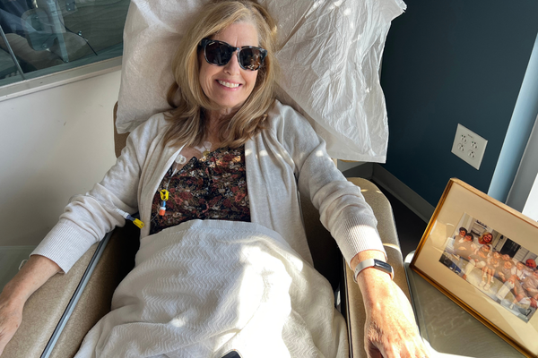 Laura smiling in sunglasses during a "Chemo Beach" treatment session.