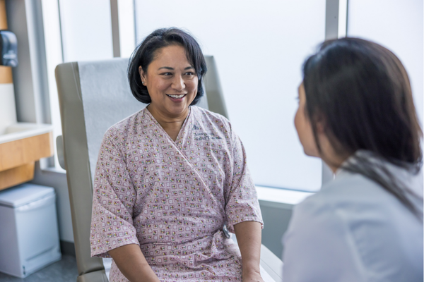 A patient sits with her doctor before receiving a Pap smear. 