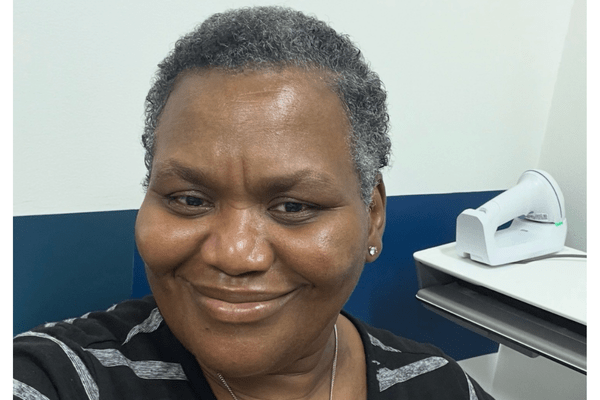 Kimberly Jenkins smiles for a photo in an Ascension medical office, with medical equipment visible behind her.