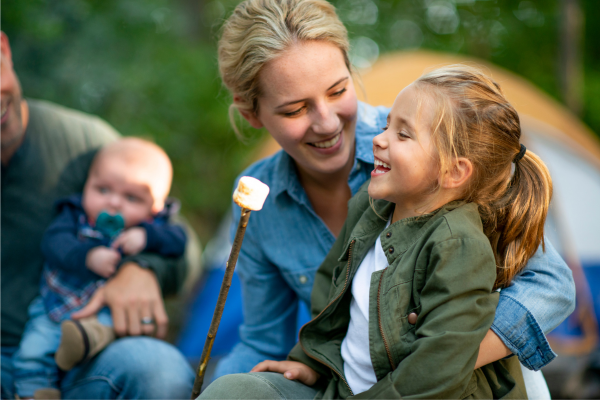 A family enjoys roasted marshmallows while camping.