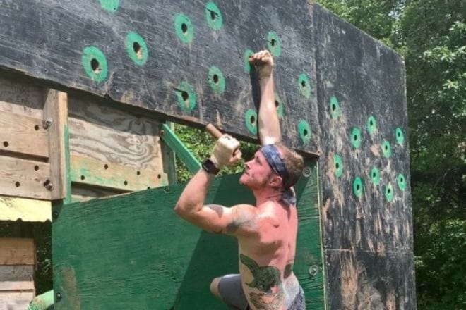 Austin McQuilken participating in an obstacle course race activity, peg boards, which caused him the most shoulder pain before attending Ascension Via Christi Physical Therapy. 
