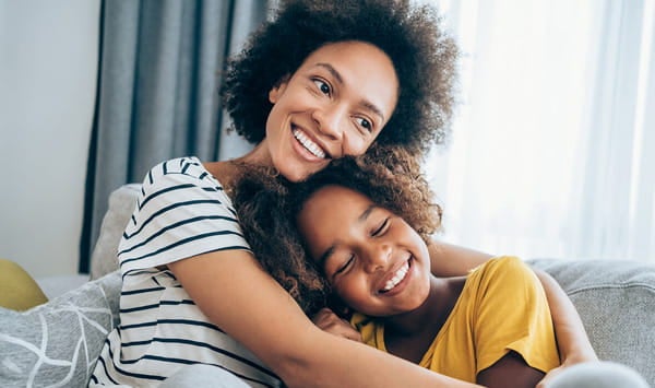 Mom hugging daughter.