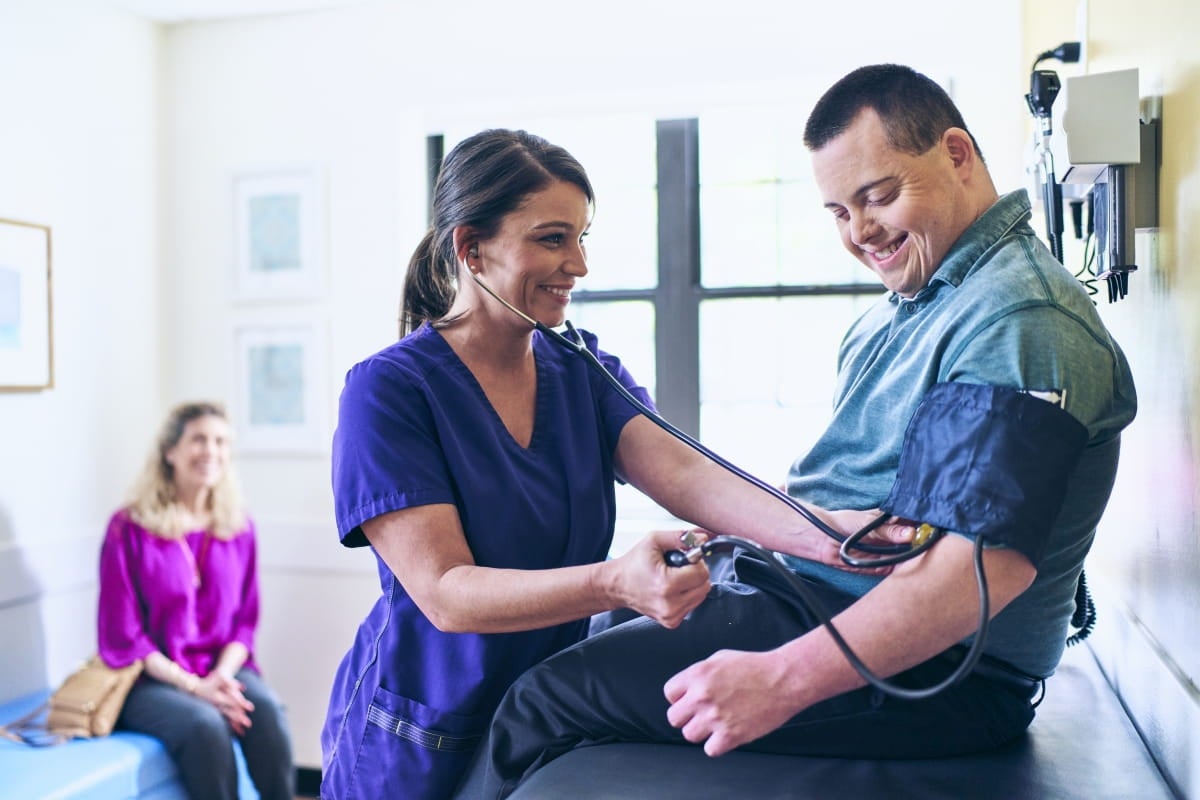A nurse is examining  a patient in a medical examination room.