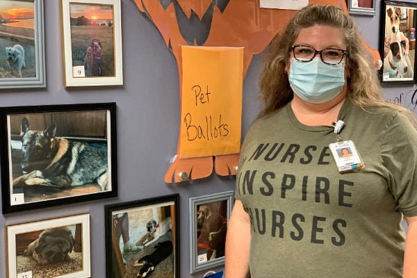 Lindsay Holman, RN, in front of the COVID-19 unit pet wall 
