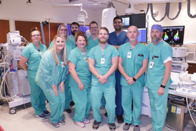 The team at the Heart Center cath lab in Pittsburg, KS poses with Dr. Khalid (back).