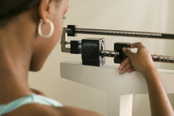 Patient on a scale. Ascension Saint Thomas Bariatric Programs assists patients on their weight loss journey.