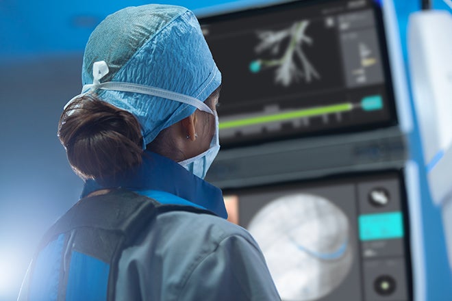 Ion pulmonologist looking at screen for ion robotic assisted surgery, designed for lung and esophageal lung cancer diagnosis and treatment. 