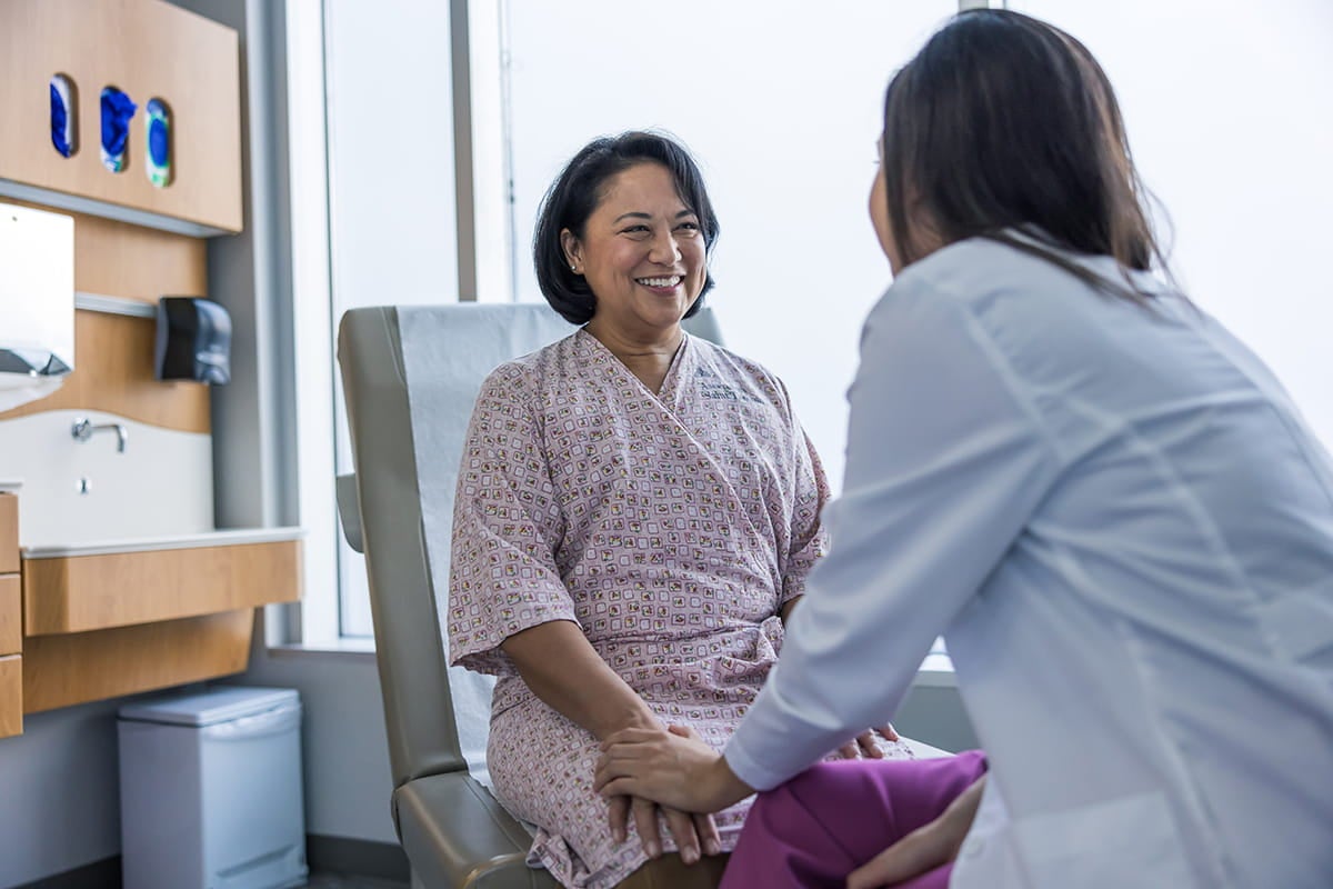 A woman is talking to a doctor during a medical examination.