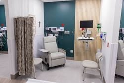 Private emergency treatment bay with reclining chair, patient monitor and medical equipment.