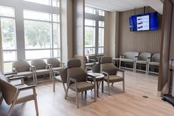 Bright emergency department waiting room with accessible seating and large windows.