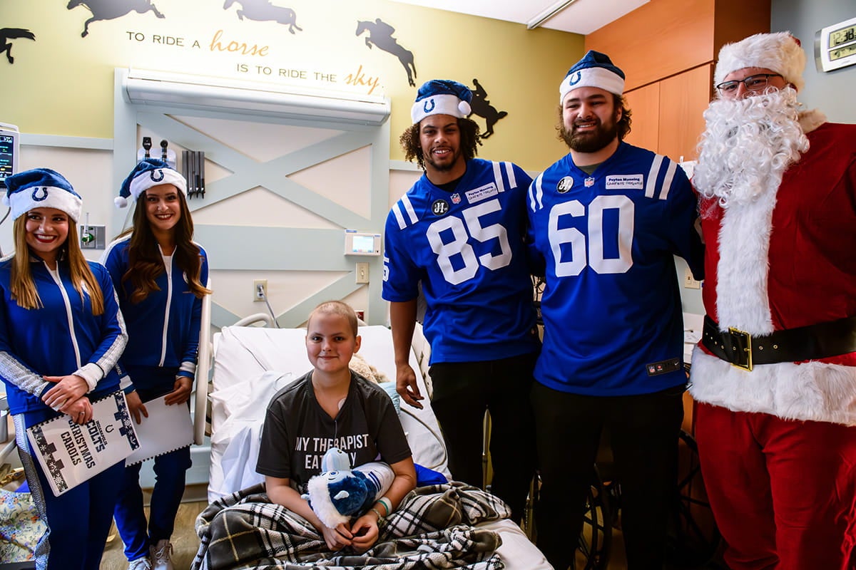 Colts players and Santa visit a pediatric patient in a hospital room at Ascension St. Vincent