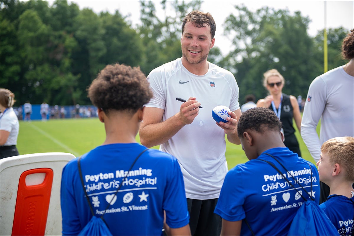 Indianapolis Colts player signs a football for children from Peyton Manning Children’s Hospital.