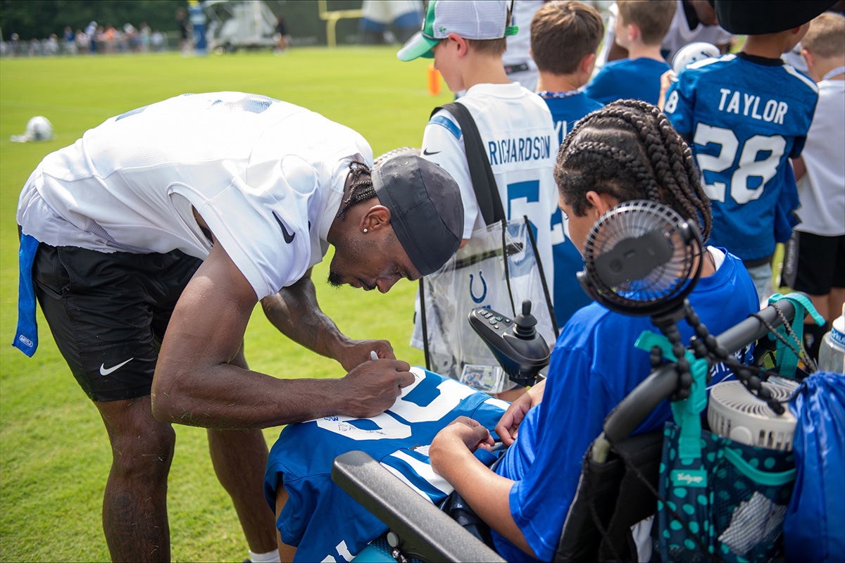 Indianapolis Colts player signs a jersey for a child from Peyton Manning Children’s Hospital.