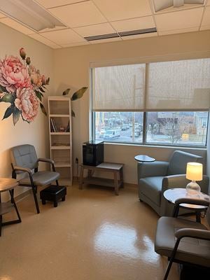 Comfortable seating area in the “Chill Zone” at Ascension Saint Agnes, featuring cushioned chairs, soft lighting, and a large floral wall mural, creating a calming environment for patients undergoing scalp cooling therapy during chemotherapy.