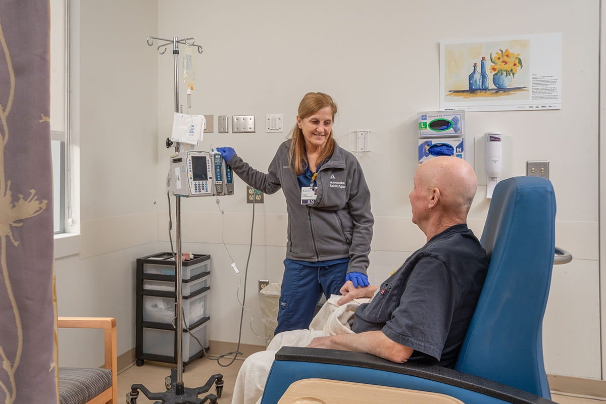 Man with nurse; oncology care teams at Ascension Saint Agnes Hospital Cancer Institute focus on you.