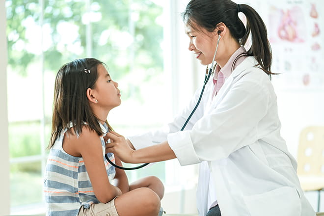 Pediatrician performs general health exam on a young patient. 