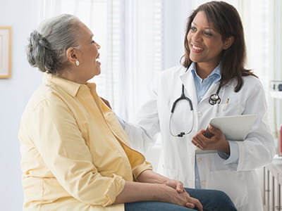 Woman talks with her doctor at an Ascension site of care. 