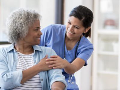 Woman visits with her nurse at an Ascension site of care. 