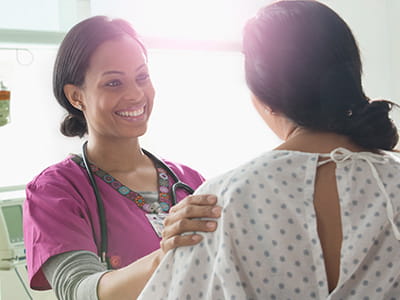 Breast cancer patient is comforted by a nurse at an Ascension site of care.