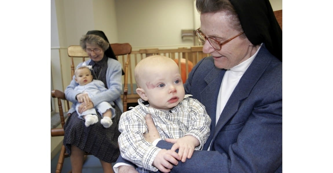 Sister Connie and Sister Ann holding babies.
