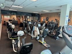 Wellness Center cardio equipment area with stationary bikes, ellipticals, and rehabilitation exercise machines supporting personalized fitness routines and healthy lifestyle goals.