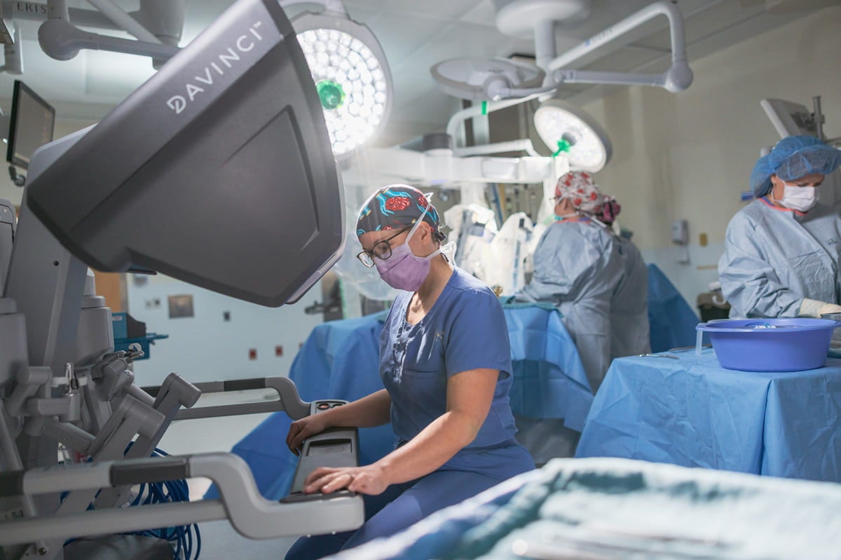 Surgical team working with a da Vinci robotic surgical system in an operating room.