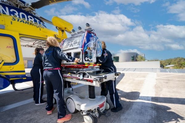 DCMC critical care transport team with helicopter.